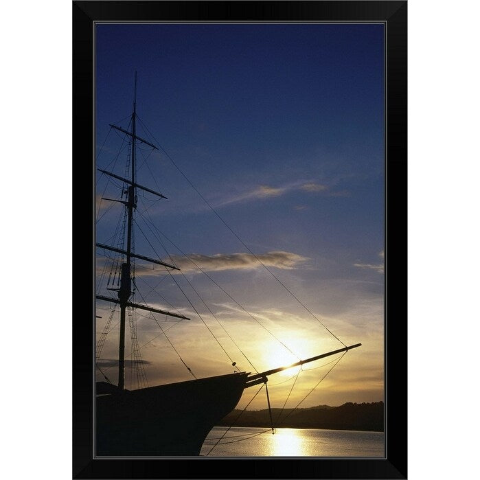 "A setting sun silhouettes an old sailing ship" Black Framed Print