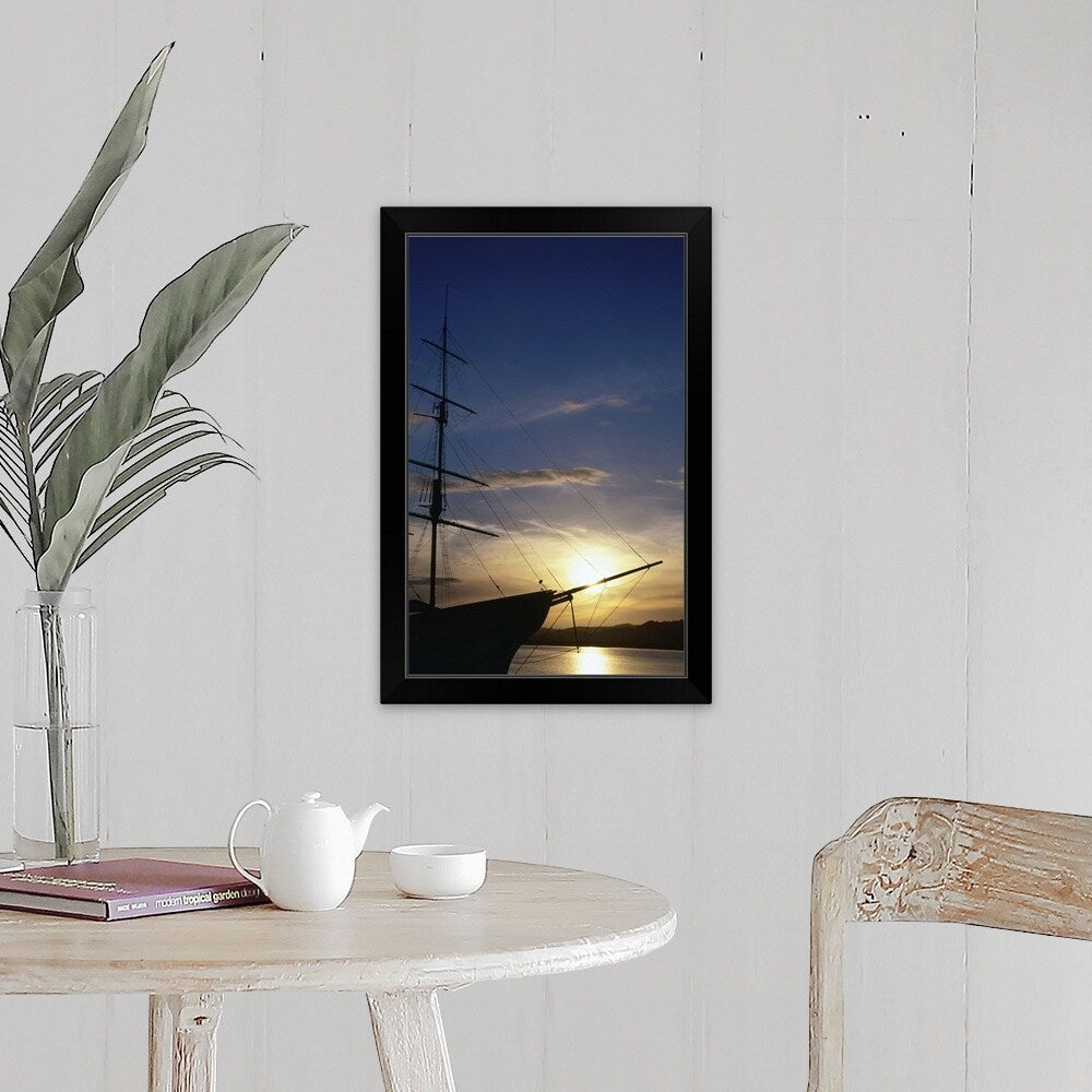 "A setting sun silhouettes an old sailing ship" Black Framed Print