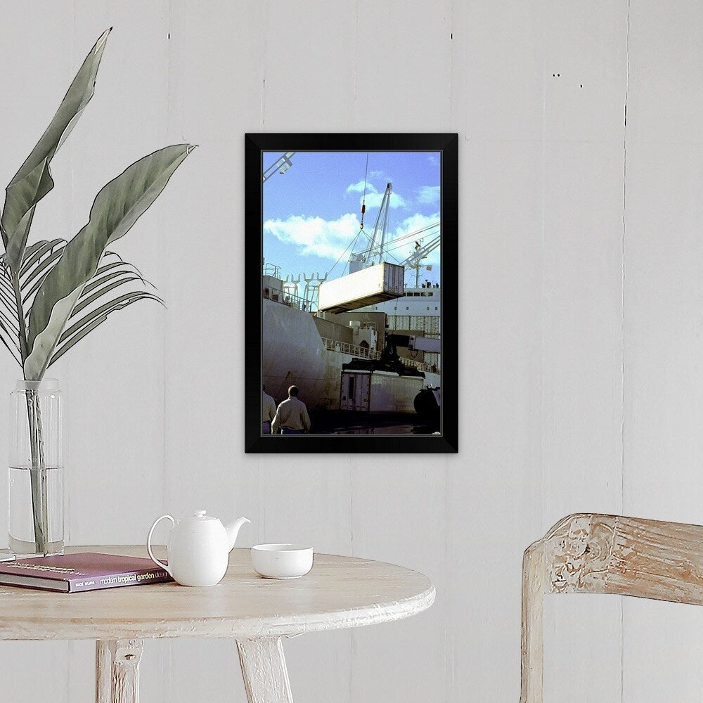 "Cranes carrying cargo containers at a port" Black Framed Print