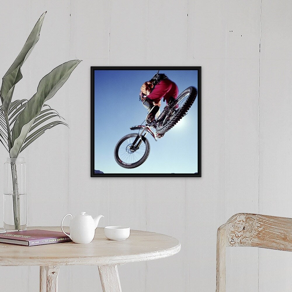 "Mountain biker riding over rocky terrain, view from below" Black Float Frame Canvas Art