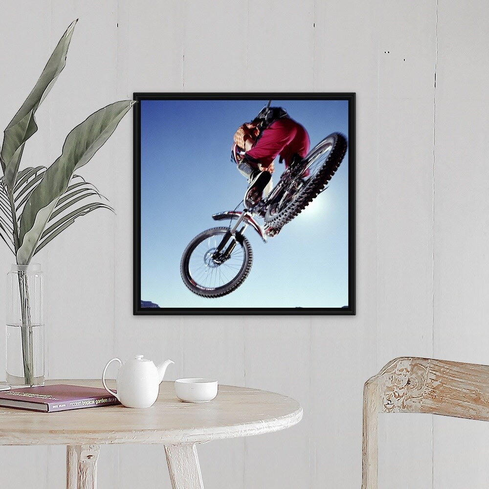 "Mountain biker riding over rocky terrain, view from below" Black Float Frame Canvas Art
