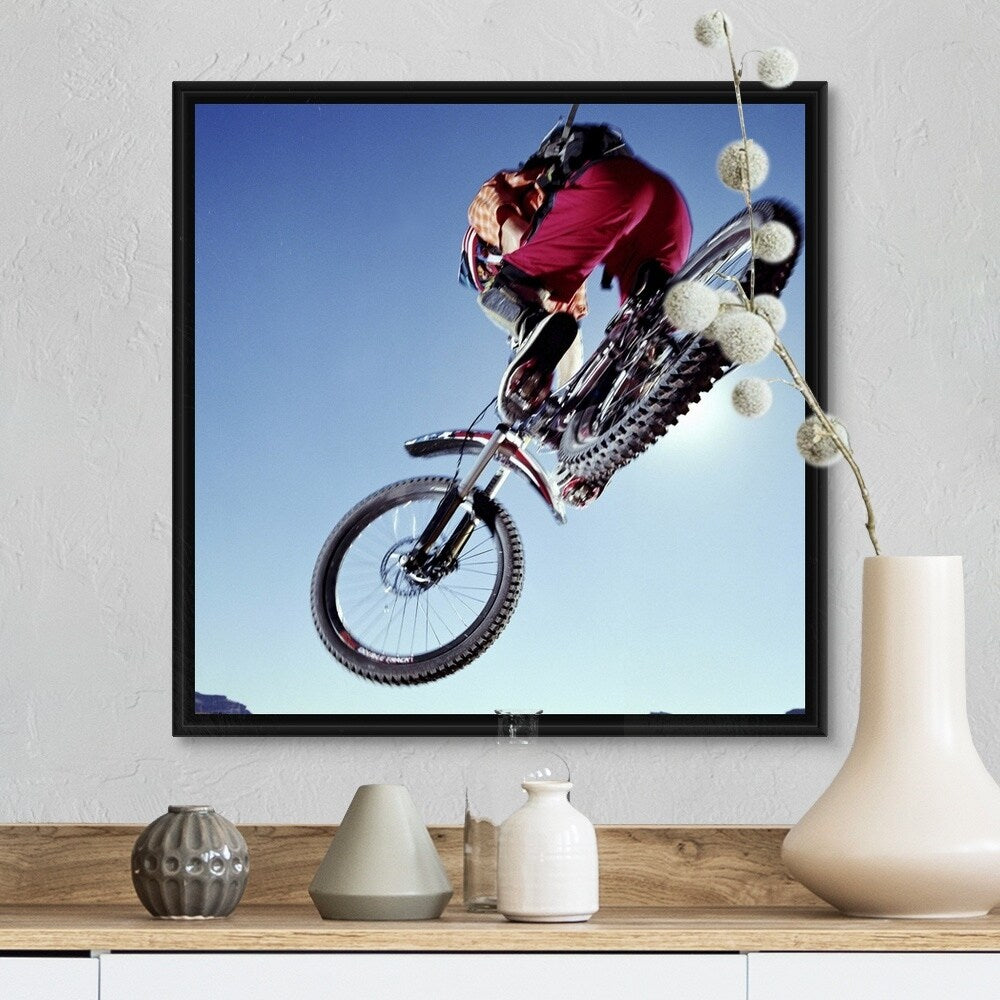 "Mountain biker riding over rocky terrain, view from below" Black Float Frame Canvas Art