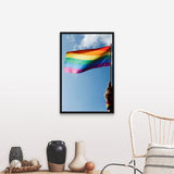 "Person's hand holding rainbow-colored flag waving in the sky" Black Float Frame Canvas Art