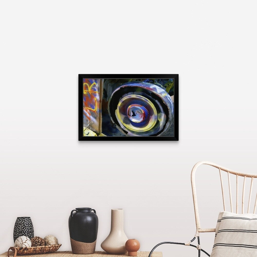 "Wheel of a half-buried Cadillac covered in graffiti, Cadillac Ranch Monument." Black Framed Print