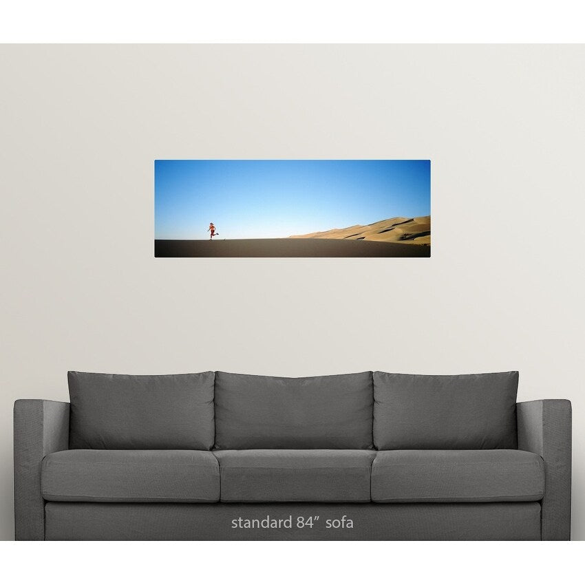 Rear view of a woman running in the desert, Great Sand Dunes National Monument, Colorado - Multi